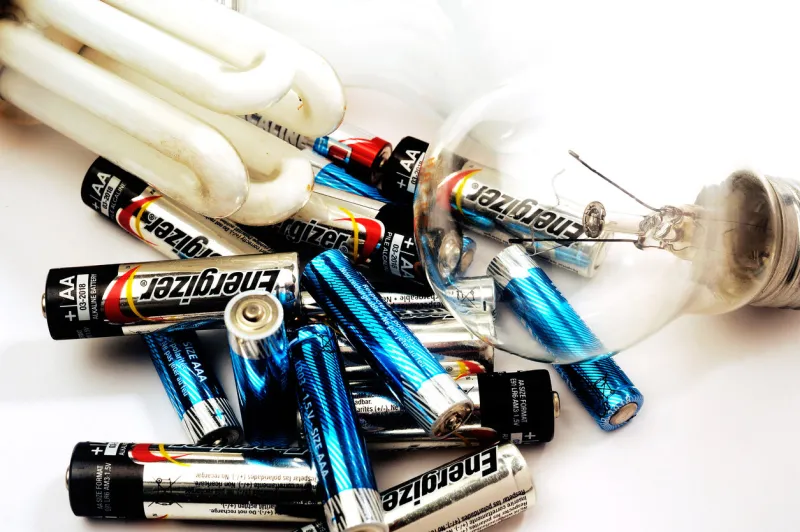 tornac, france - november 9, 2014  recycling of used batteries and bulbs on white background