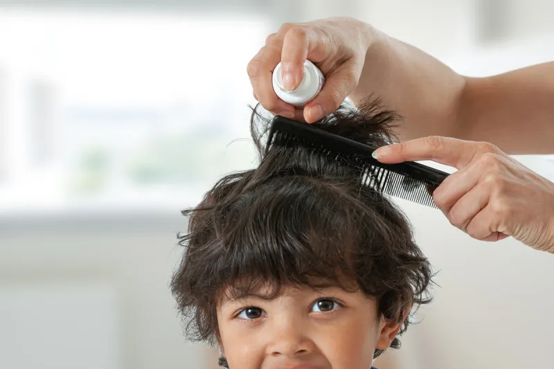 mother treating daughter's hair against lice head lice treatment for schoolchild