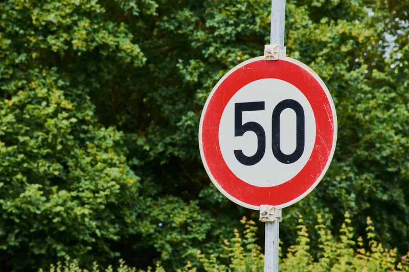 traffic sign with speed limit 50 against a green background
