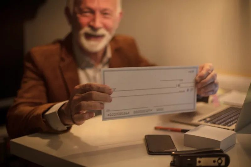 i provided my old days senior man holding a blanco check close up focus on hands