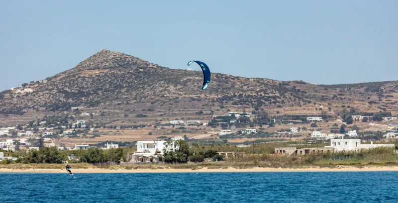 kitesurfing in aegean blue sea at pounta beach paros island cyclades greece kiteboarding, extreme sport speed adventure