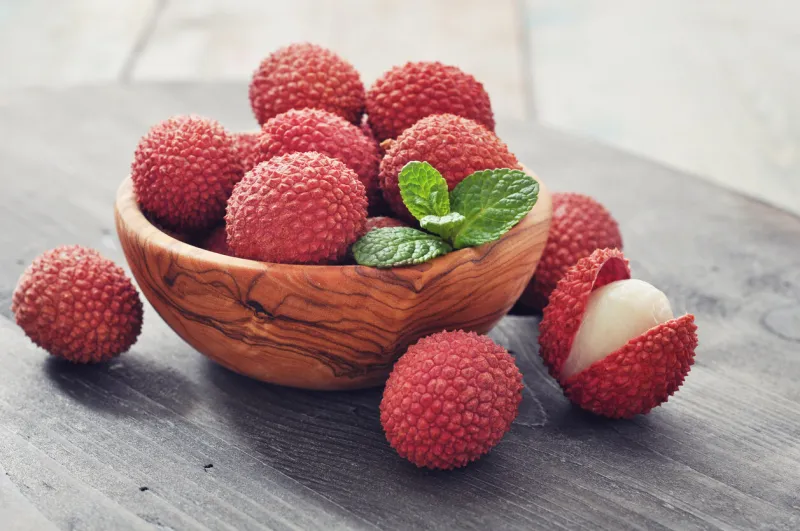 fresh lychee in bowl on a wooden background