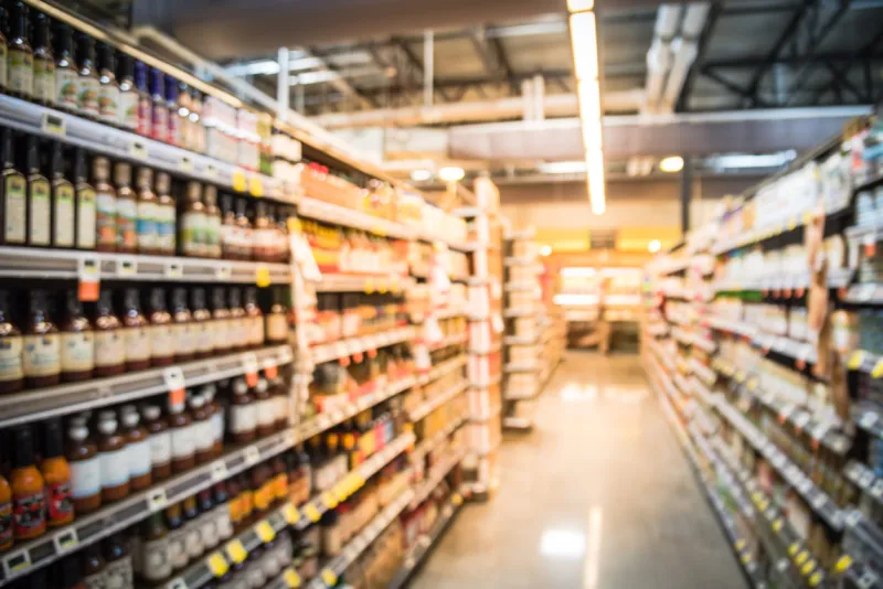 blur selection of salad dressing, pickles, condiments, and canned beans veggies soups on shelves in store at houston, texas, us defocused background of aisles, rows and variety product in supermarket