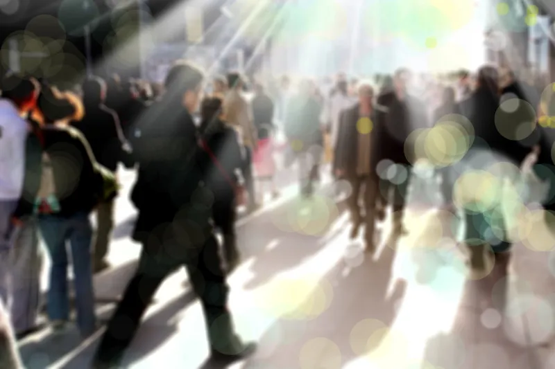 blurry background image of people walking on busy street