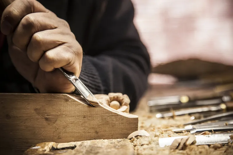 an engraver is carving a piece of wood frame