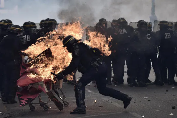 des policiers français anti-émeute crs tentent de repousser un chariot incendiaire lancé vers eux lors d'une marche pour le rassemblement annuel des travailleurs du 1er mai à paris le 1er mai 2017 afp photo philippe lopez