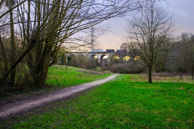 epinay-sous-sénart, france - january 17, 2021  train passing on a stone viaduct at sunset taken on a sunny winter day near paris, france