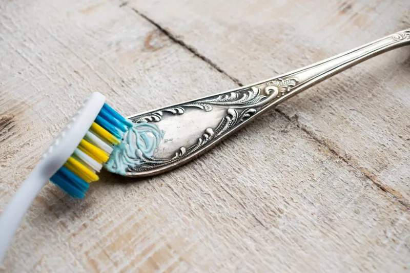 cleaning the cutlery with a brush and paste cleaning darkened silverware with toothpaste or cleaning paste