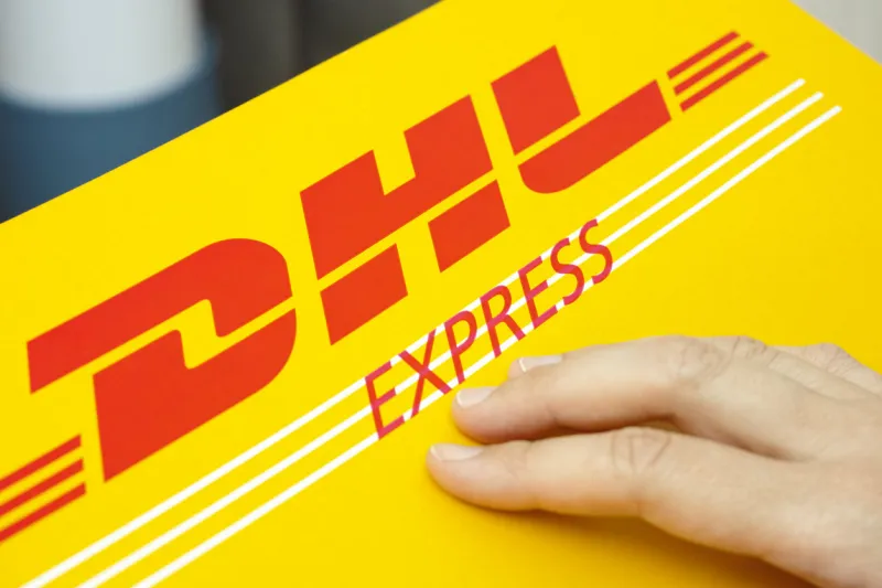 tambov, russian federation - june 01, 2015  dhl express package with human hand studio shot