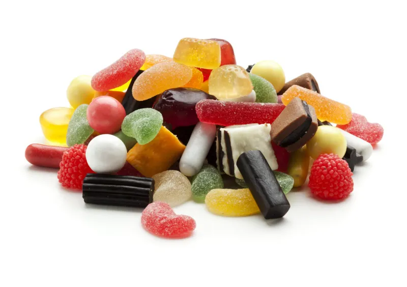 heap of jelly beans, wine gums and liquorice candy isolated on white