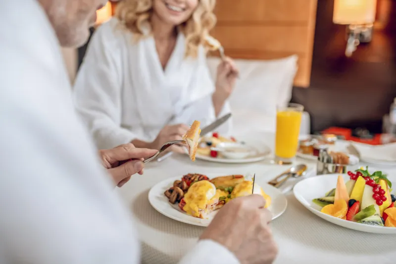 breakfast time a couple in white robes having breakfast and looking pleased
