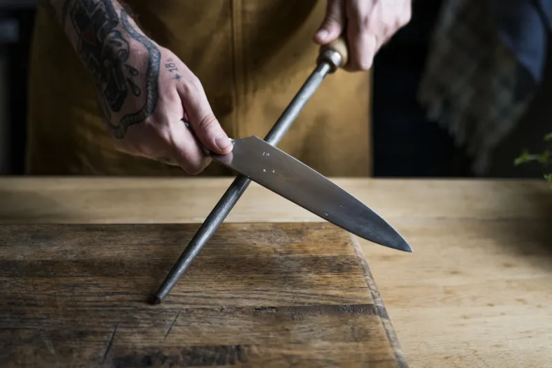 professional chef sharpening knife in the kitchen