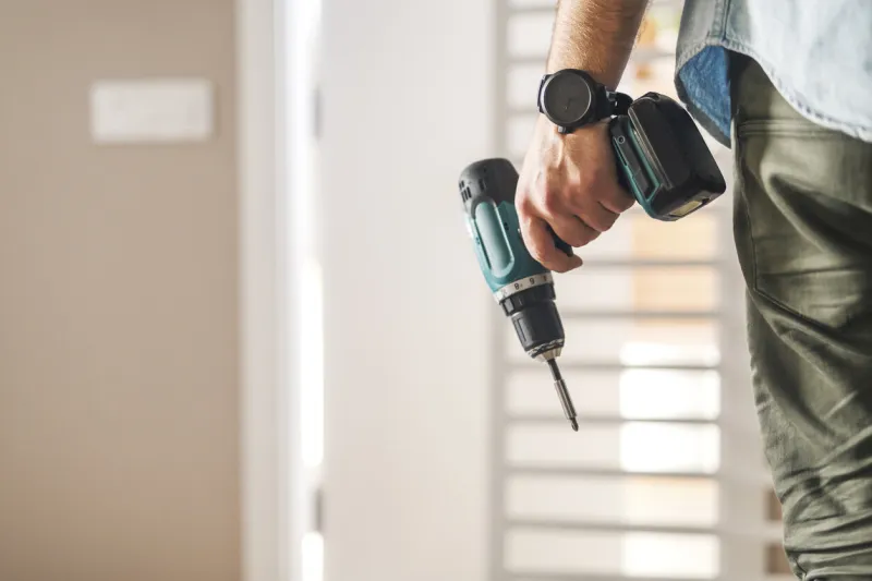 close up of electric screwdriver in male hand