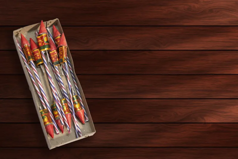 firecrackers in a cardboard box on a wooden background top view copy space