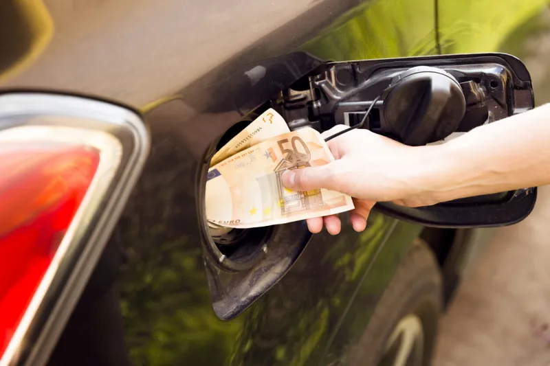 transportation expenses concept - euro money in car fuel tank
