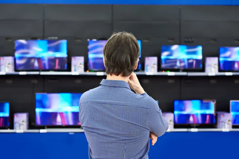 man looks at lcd tvs in supermarket