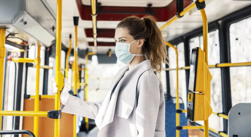 woman wearing surgical protective mask going to work