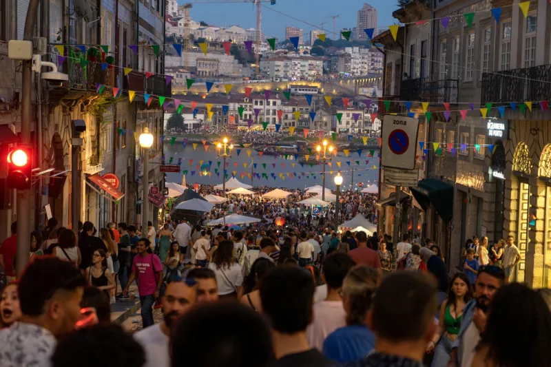 06232023 porto, portugal  festa de sao joao do porton many happy people on the street with plastic hammer on the sao joao festival a funny event in porto portugal