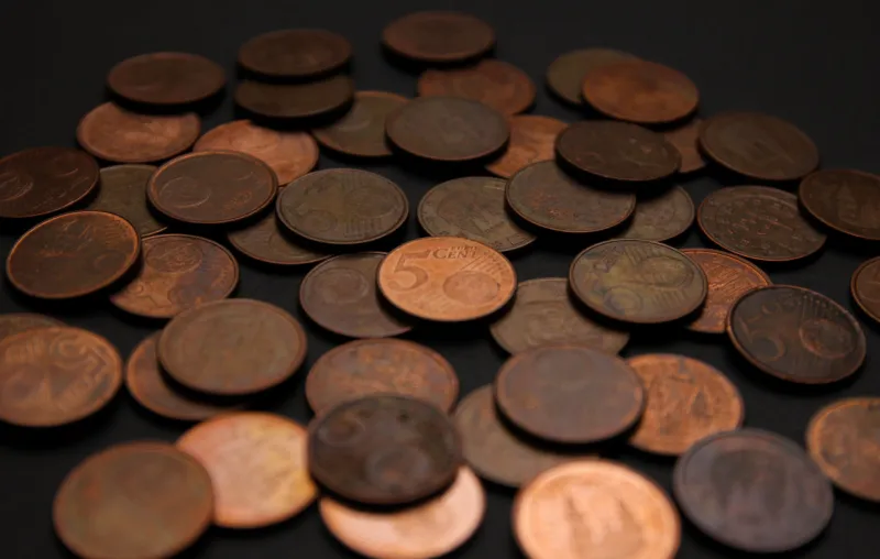 close-up photography of a bunch of euro coins of five cents on a black background