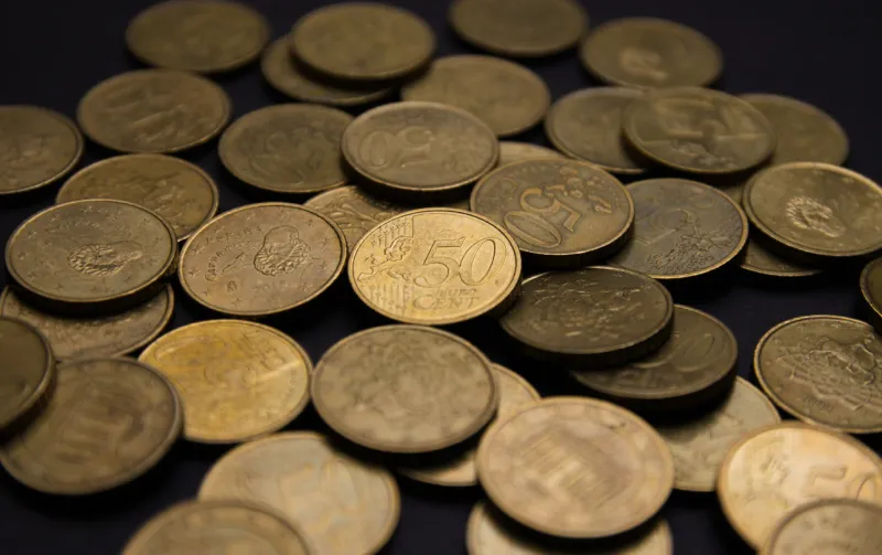 close-up photography of a bunch of euro coins of fifty cents on a black background