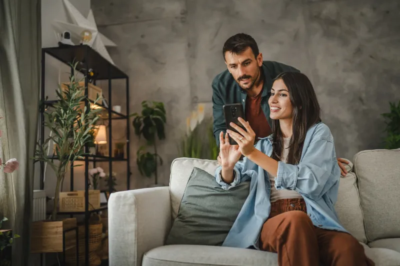 wife navigate with cellphone her husband how to set cctv camera on the wall at home