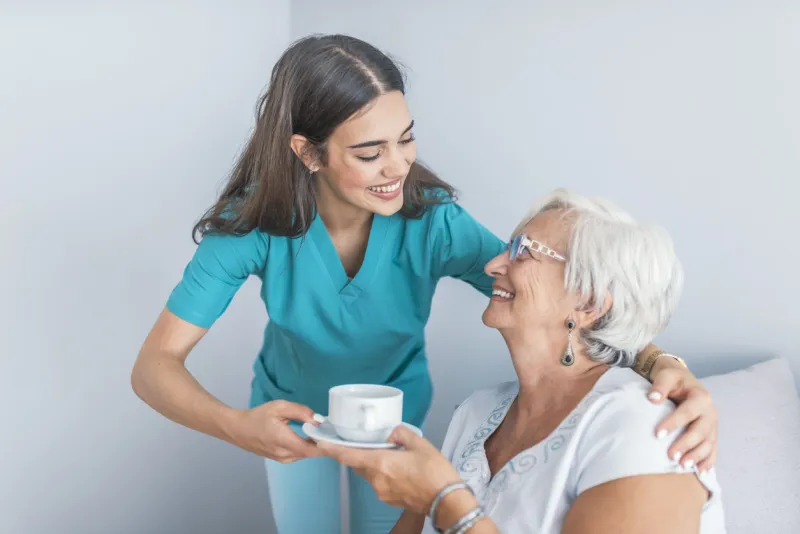 pretty helpful carer talking with female patient health visitor and a senior woman during home visit supportive senior care assistant and smiling older woman in nursing home