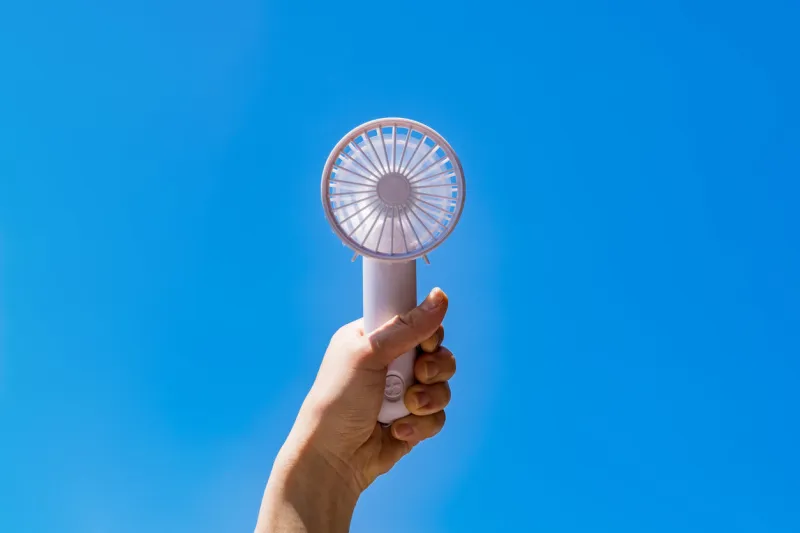 portable handy fan in summer blue sky
