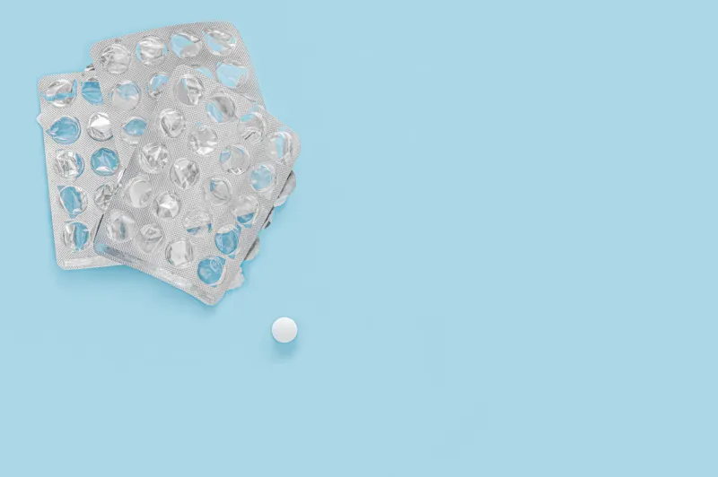 last pill empty pill packaging drug shortage deficiency concept empty packs of pills and last pill isolated on blue background top view copy space