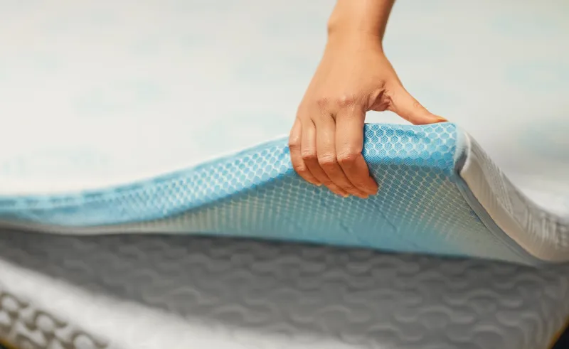 woman hand testing orthopedic memory foam mattress topper