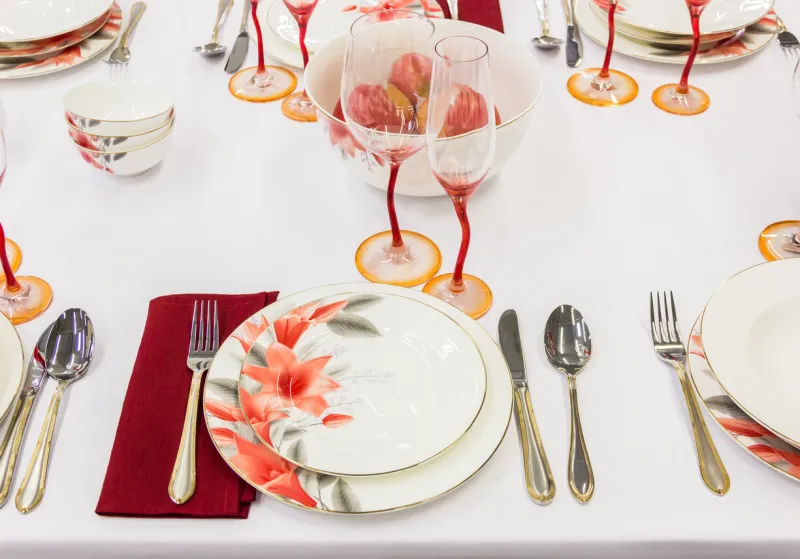 table setting with tableware, cutlery and a red glass