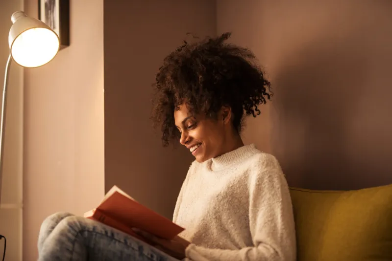 african american girl reading a book at home