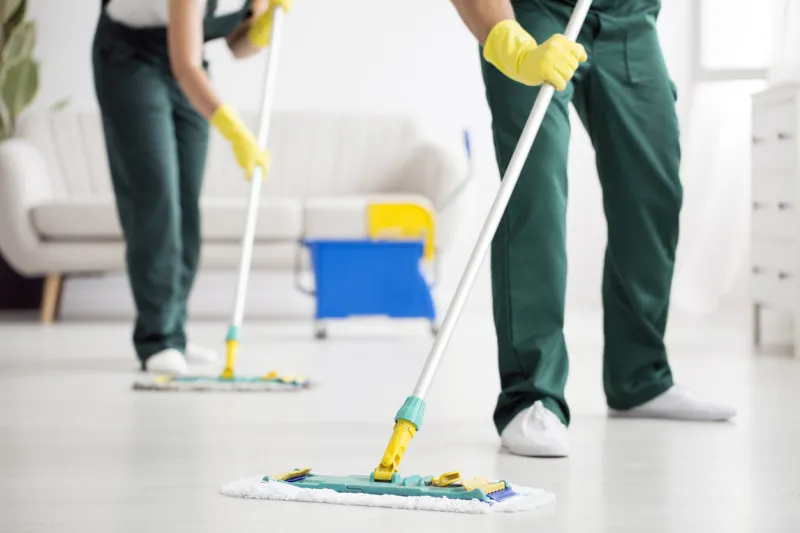 cleaning team wiping the floor using mops in the flat