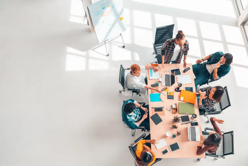 multiethnic diverse group of business coworkers in team meeting discussion, top view modern office with copy space partnership professional teamwork, startup company, or project brainstorm concept