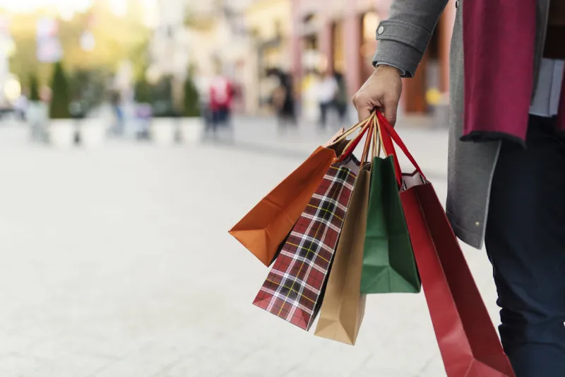 man holding shopping bags with presents on the street