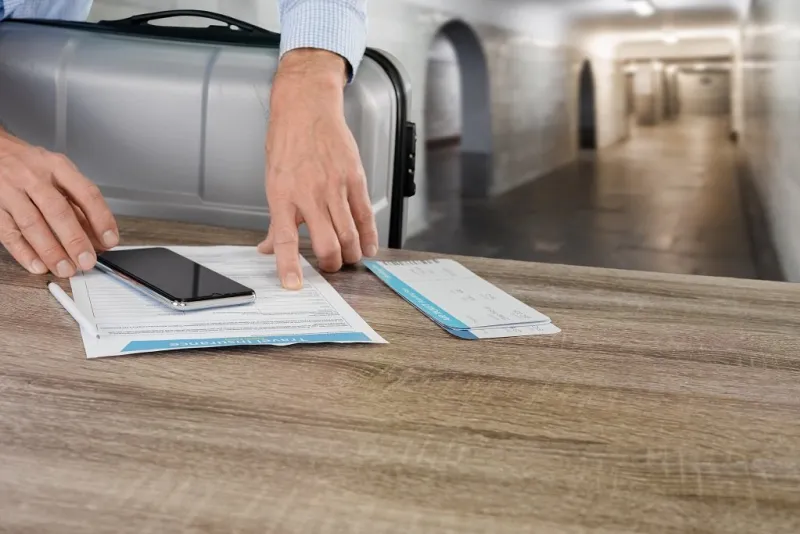 closeup of male businessman checking travel insurance contract before flight