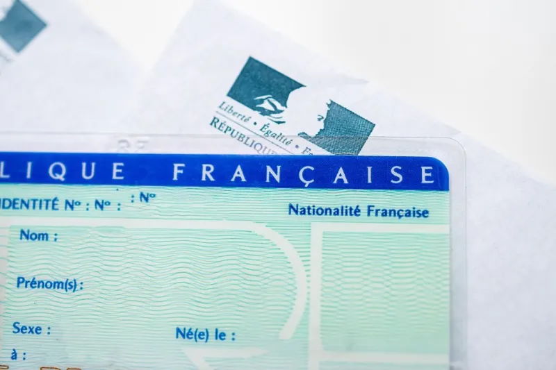 paris, france - mar 31, 2019  close-up macro shot of national identity card carte nationale d identite with letter from the ministry of interior in the background