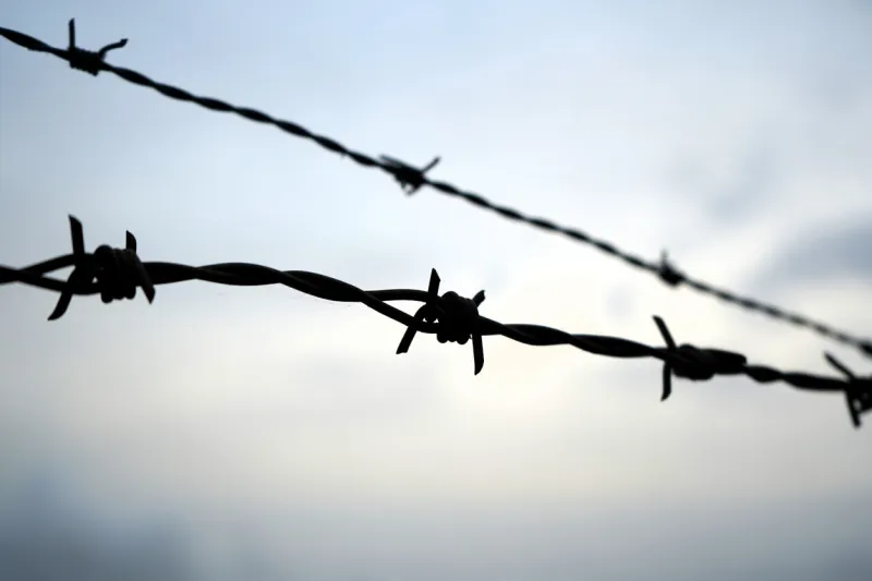 close-up of barbed wire against a background of white cloudy sky in france