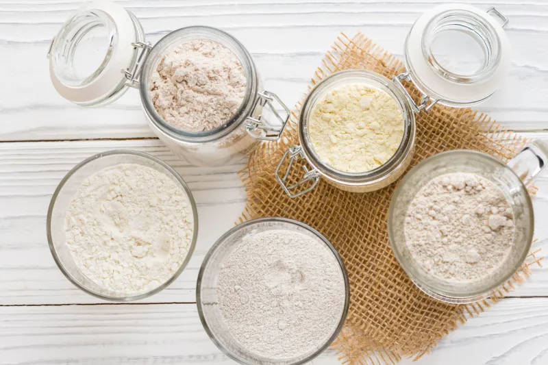 different flour in glass jars, wheat, corn, rye, oats, spelt, flax