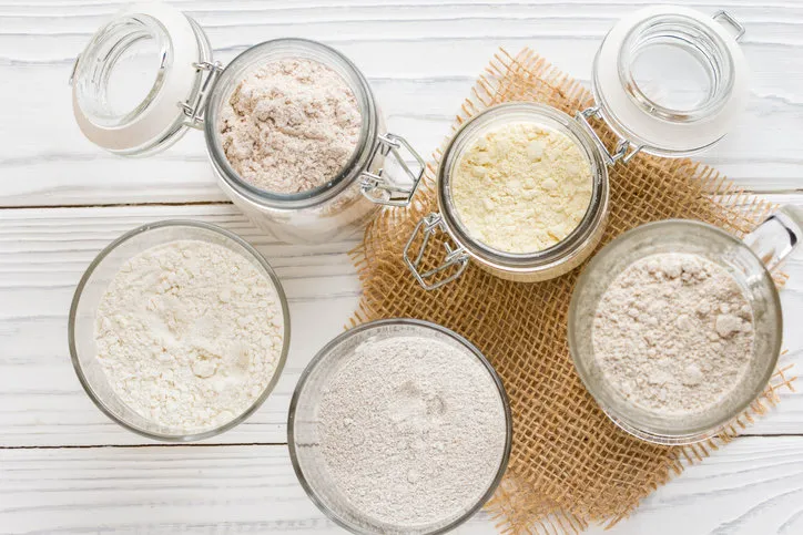 different flour in glass jars, wheat, corn, rye, oats, spelt, flax