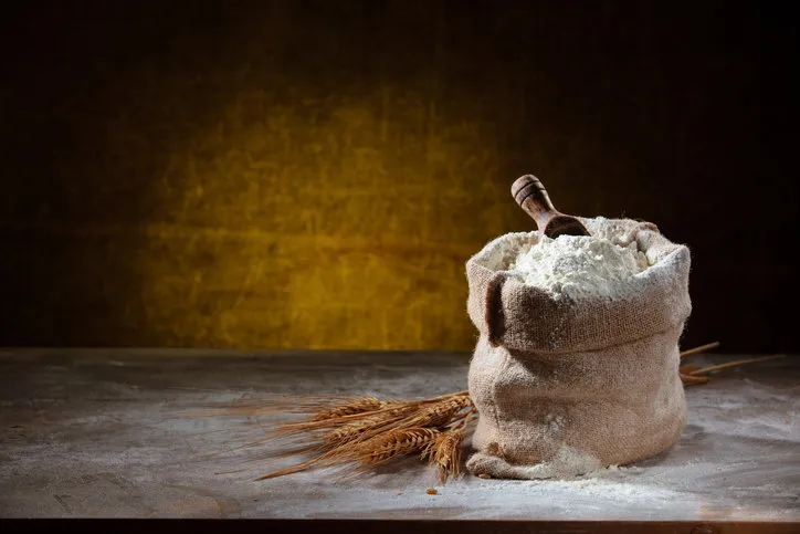 closeup shot of flour in sack on rustic wooden table