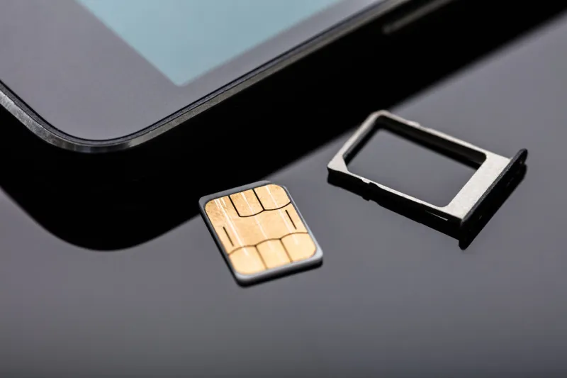 close-up of nano sim card ready to insert in smart phone over the desk
