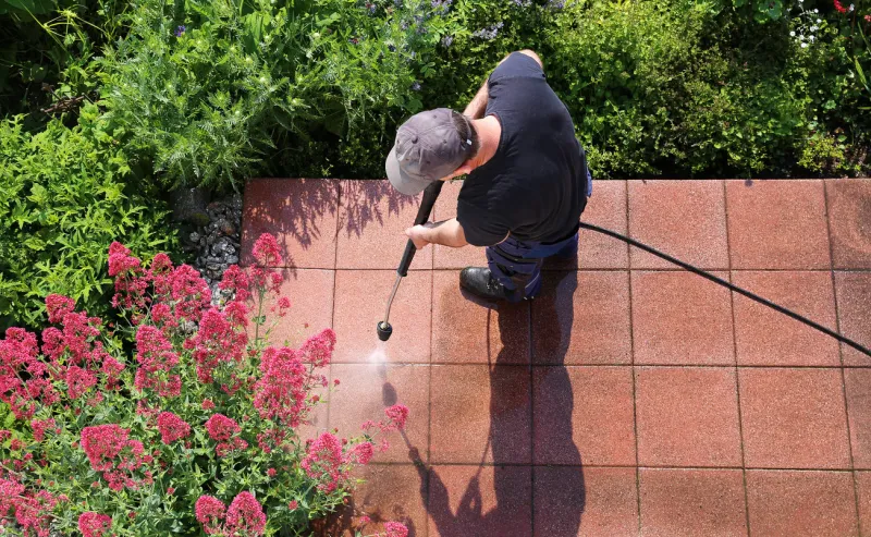 worker cleaning stone slabs with the high-pressure cleaner, seen from above, with space for text