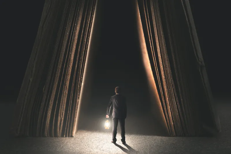 couriose man with lamp going to be wise in a book