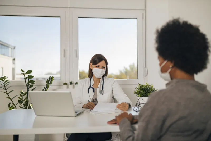adult african woman talking to doctor about her diagnoses