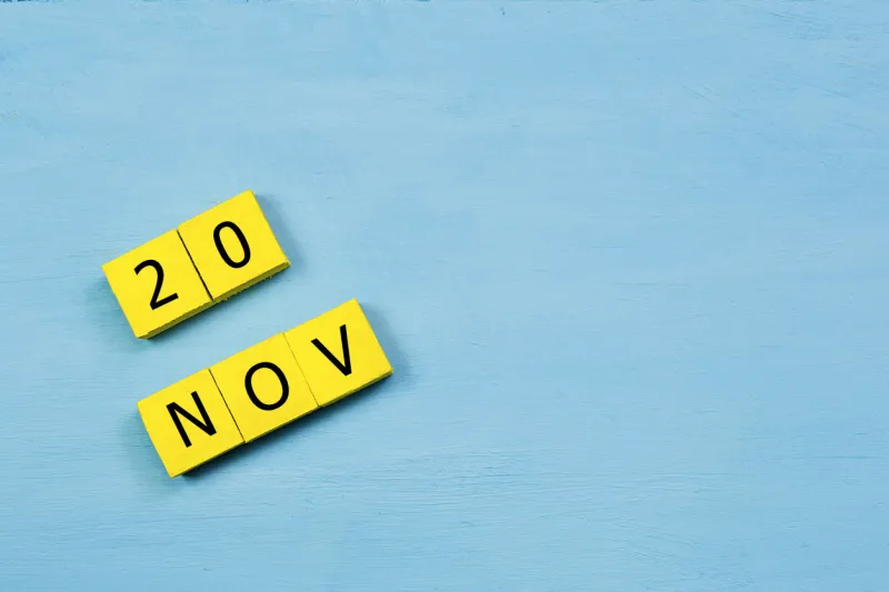 nov 20, yellow cube calendar on blue wooden surface with copy space