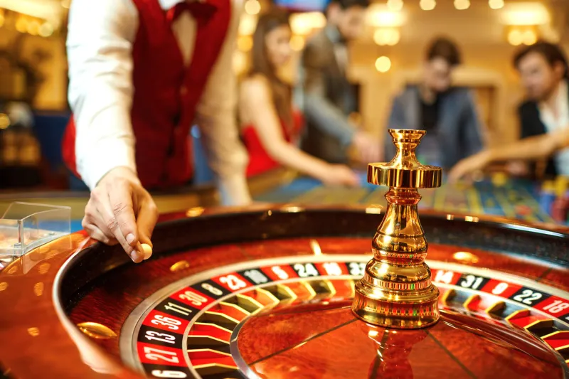 the croupier holds a roulette ball in a casino in his hand gambling in a casino