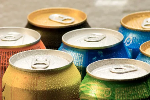 cans of soft drink cooling frozen and with water drops
