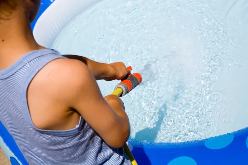 young boy filling the pool