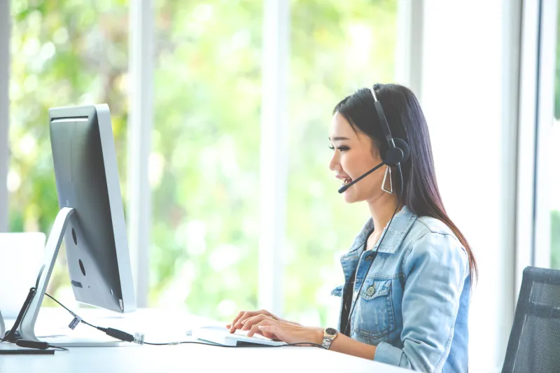 attractive business woman asian in suits and headsets are smiling while working with computer at office customer service assistant working in office