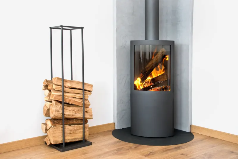 modern burning stove next to a wood logs rack